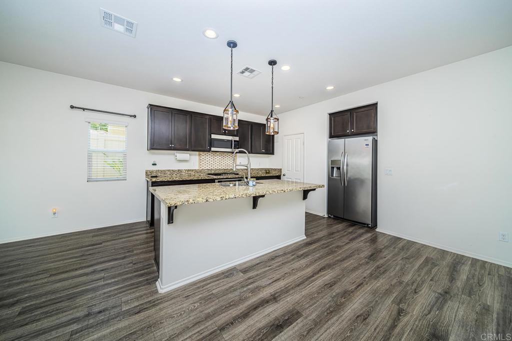 340 Falabella Lane Fallbrook, CA 92028 - Photo 13 of 63 a kitchen with stainless steel appliances granite countertop a refrigerator a stove a sink and a microwave
