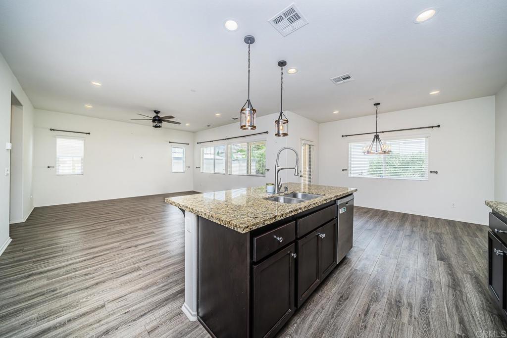 340 Falabella Lane Fallbrook, CA 92028 - Photo 17 of 63 a kitchen with stainless steel appliances granite countertop a sink a oven a counter space and wooden floor