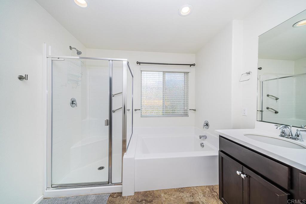 340 Falabella Lane Fallbrook, CA 92028 - Photo 36 of 63 a bathroom with a bathtub a sink a vanity and a shower
