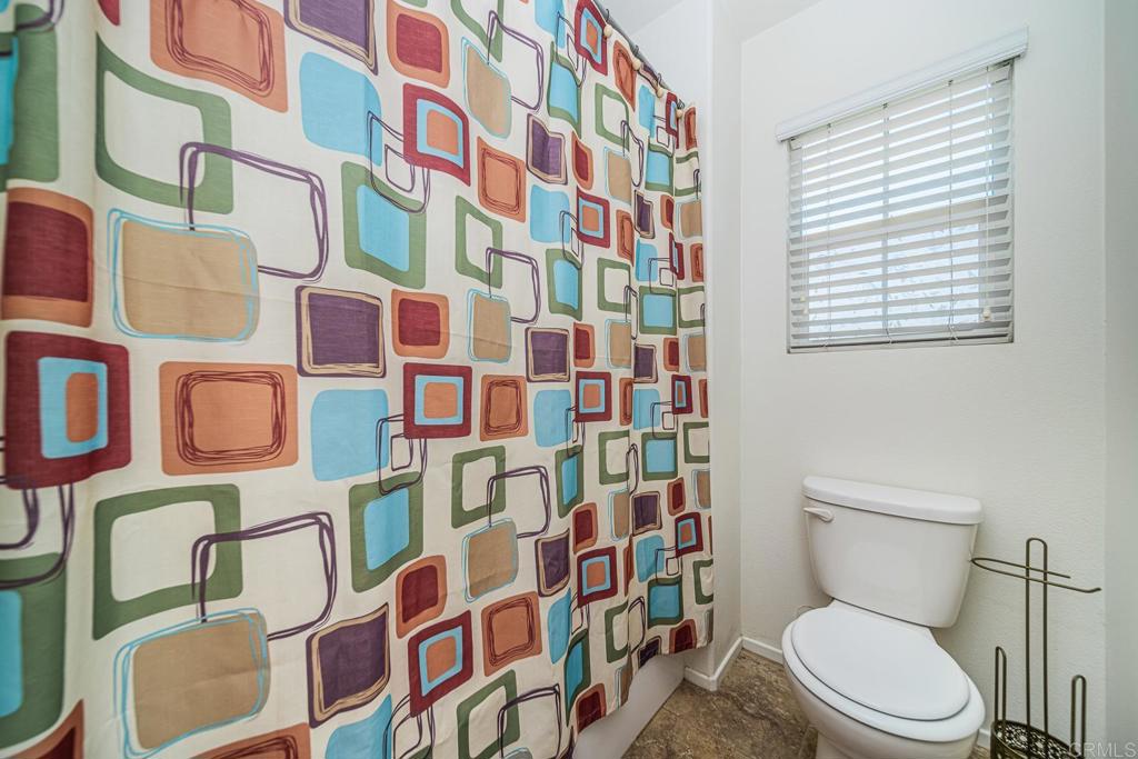 340 Falabella Lane Fallbrook, CA 92028 - Photo 42 of 63 a white toilet sitting next to a shower curtain