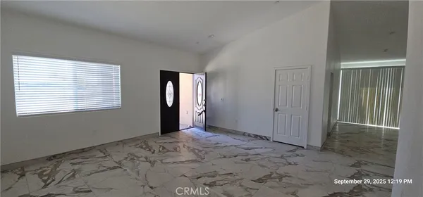 a view of an empty room with window and closet