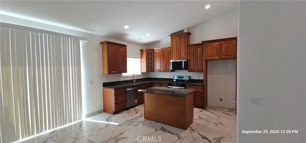 a kitchen with stainless steel appliances granite countertop a stove a sink and a refrigerator