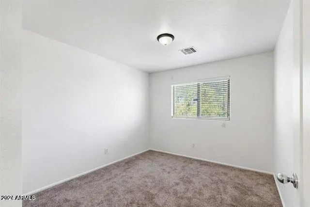 an empty room with a window and a ceiling fan