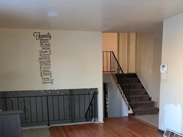 a view of a kitchen with wooden floor and a refrigerator