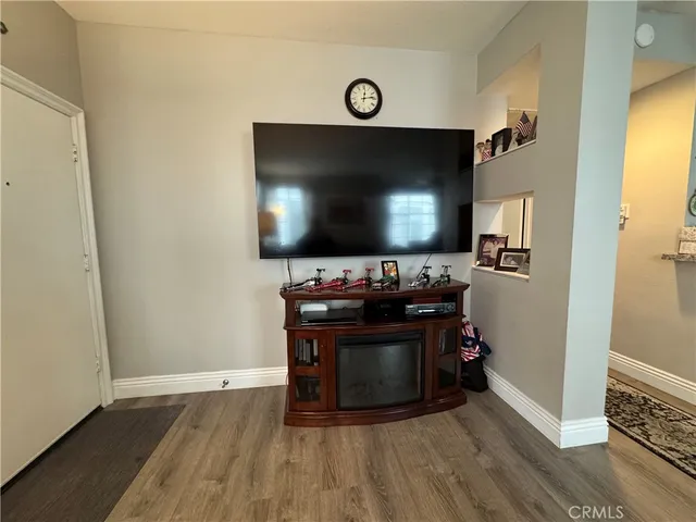 a living room with wooden floor and a flat screen tv