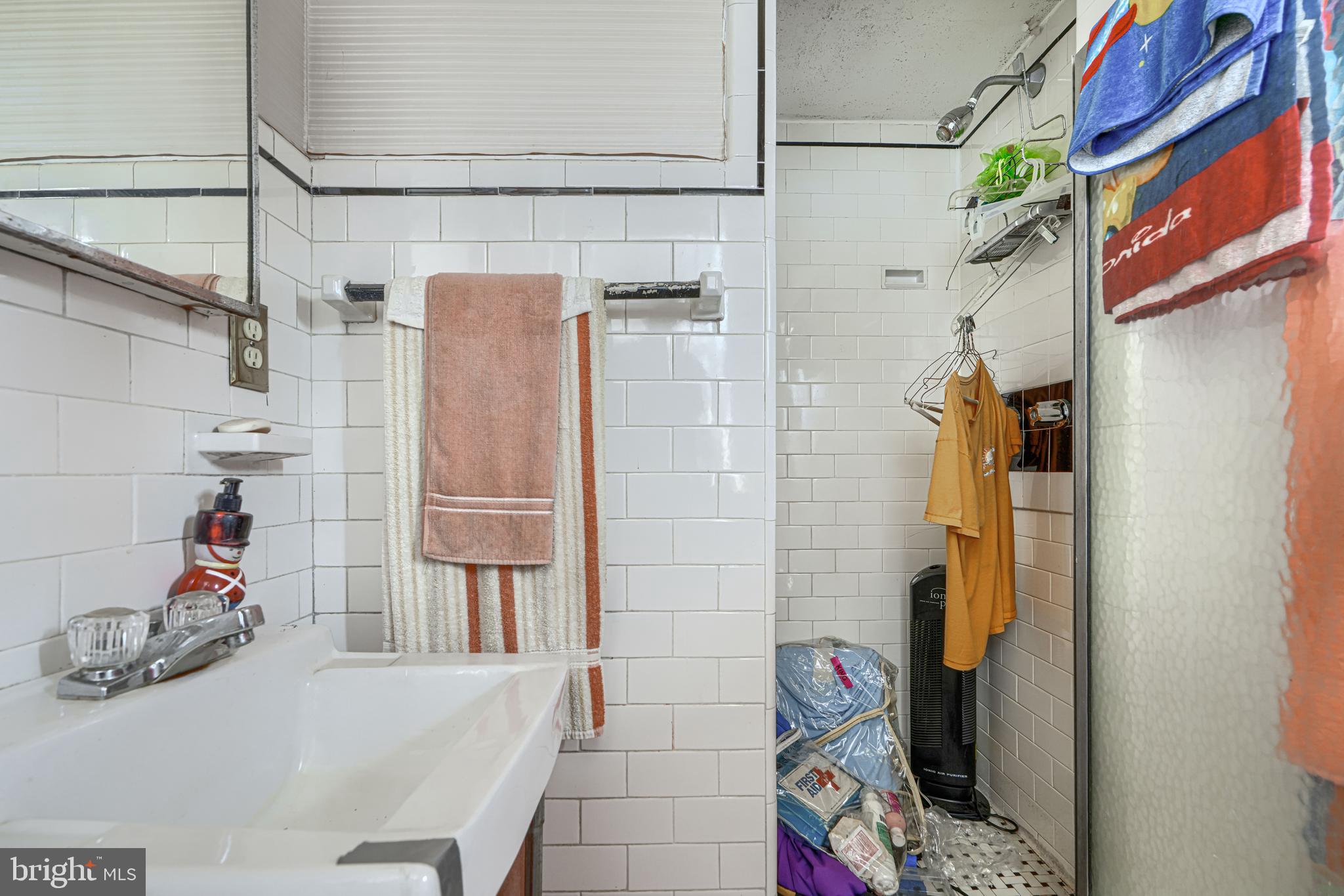 3212 Dorchester Road Baltimore, MD 21215 - Photo 24 of 45 a bathroom with a sink and a shower