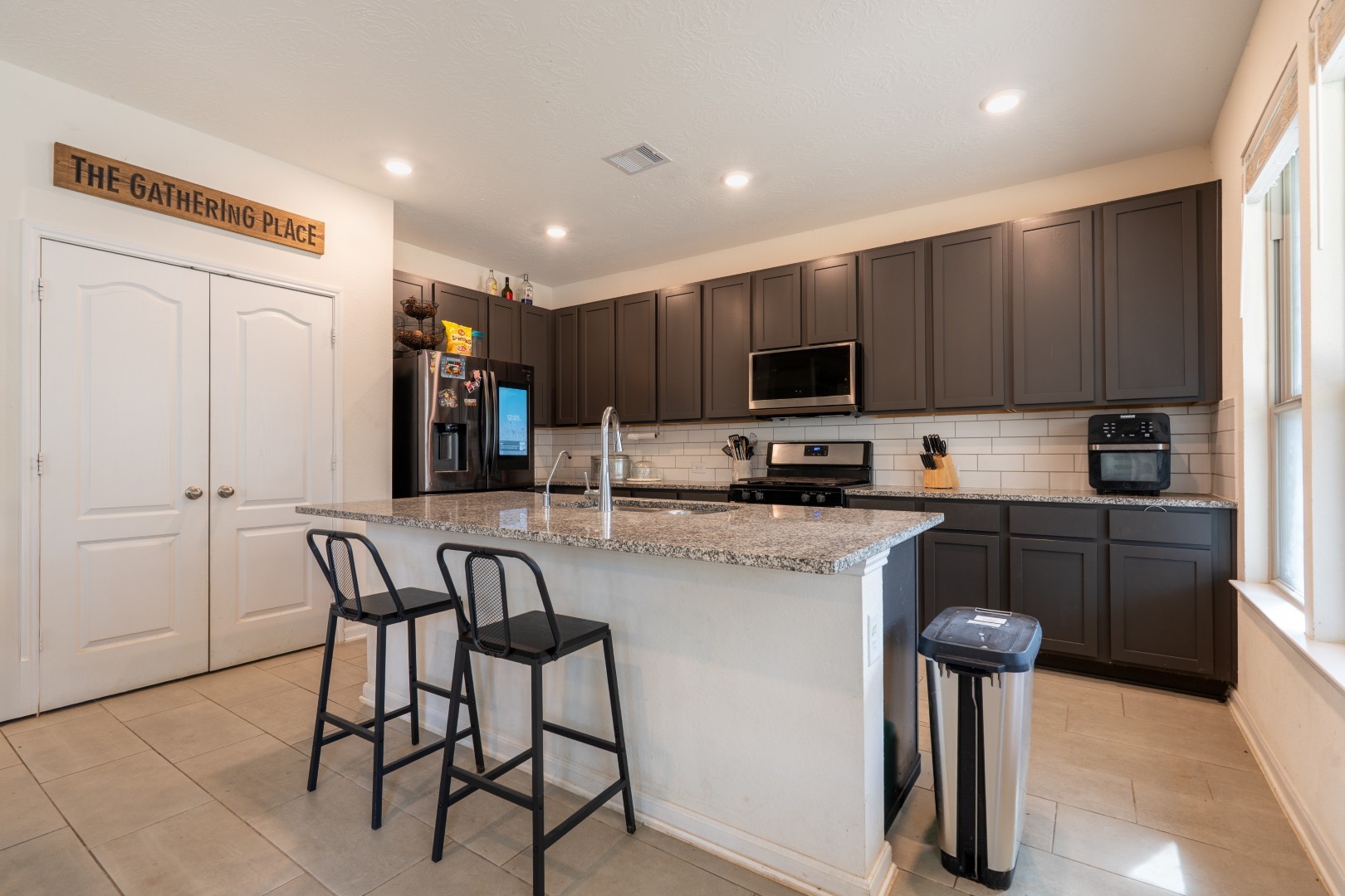 2003 Parnevik Place Conroe, TX 77304 - Photo 7 of 28 a kitchen with stainless steel appliances granite countertop a refrigerator and microwave