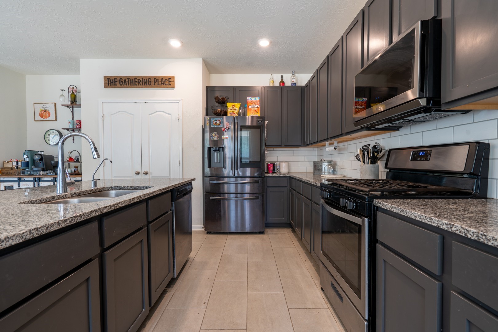 2003 Parnevik Place Conroe, TX 77304 - Photo 8 of 28 a kitchen with stainless steel appliances granite countertop a sink a stove top oven and refrigerator