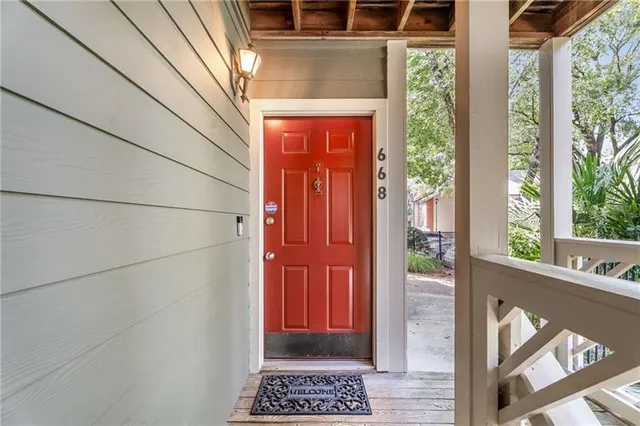 an empty room with wooden floor fireplace and windows