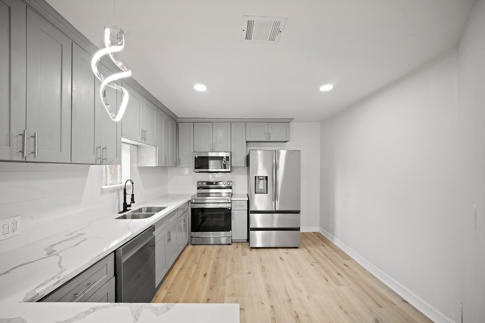 a kitchen with stainless steel appliances a refrigerator sink and stove