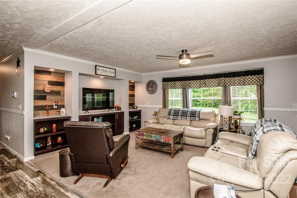 170 Houpe Road Cleveland, NC 27013 - Photo 40 of 48 a living room with furniture a flat screen tv and a large window