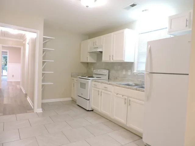 a kitchen with white cabinets and white appliances