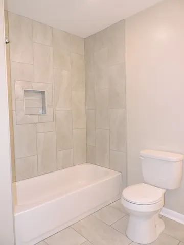 a white bath tub sitting next to a white toilet