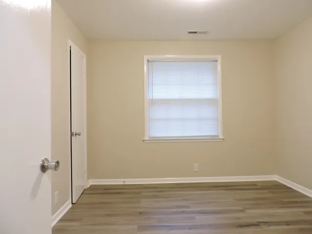 a view of an empty room with wooden floor