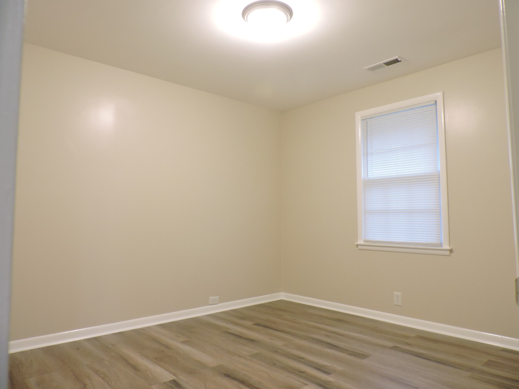 355 9th Avenue North, Unit B Franklin, TN 37064 - Photo 9 of 21 a view of an empty room with wooden floor and a window