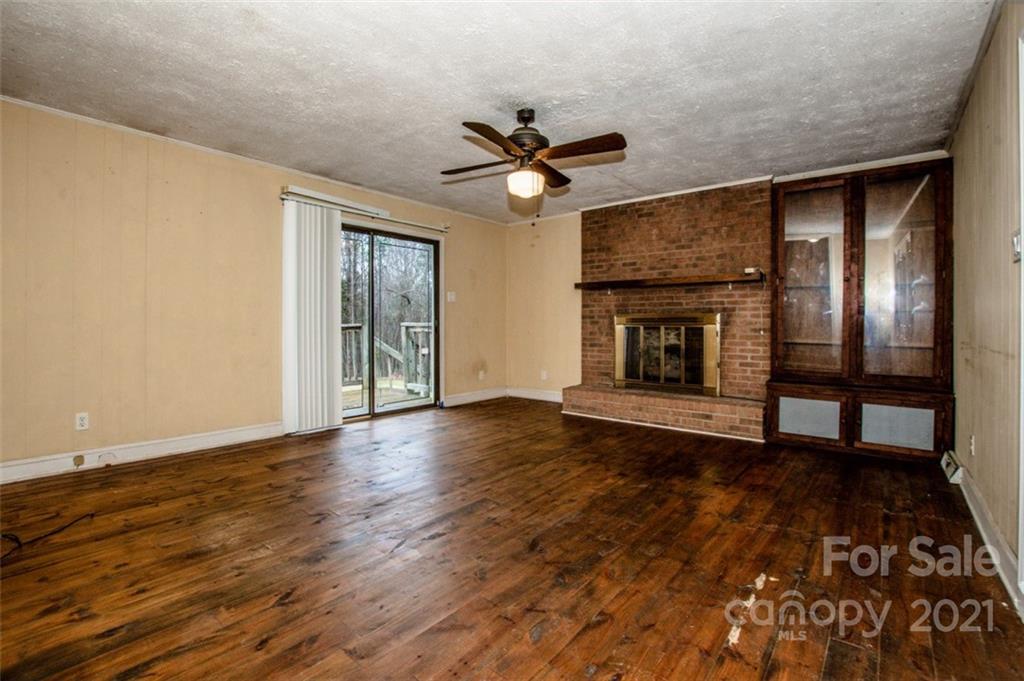 255 Rock Hump Road Salisbury, NC 28147 - Photo 25 of 39 a view of an empty room with wooden floor fireplace and a window