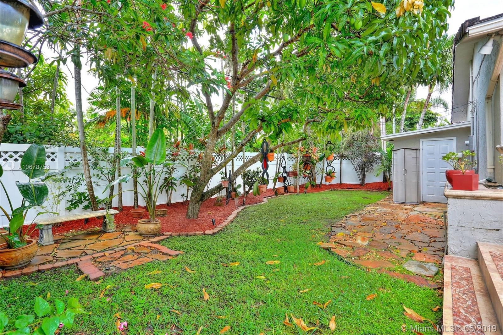 5939 Southwest 34th Street Miami, FL 33155 - Photo 27 of 30 Neatly-manicured back yard with fruitful mango tree, blooming flowers and additional storage room.