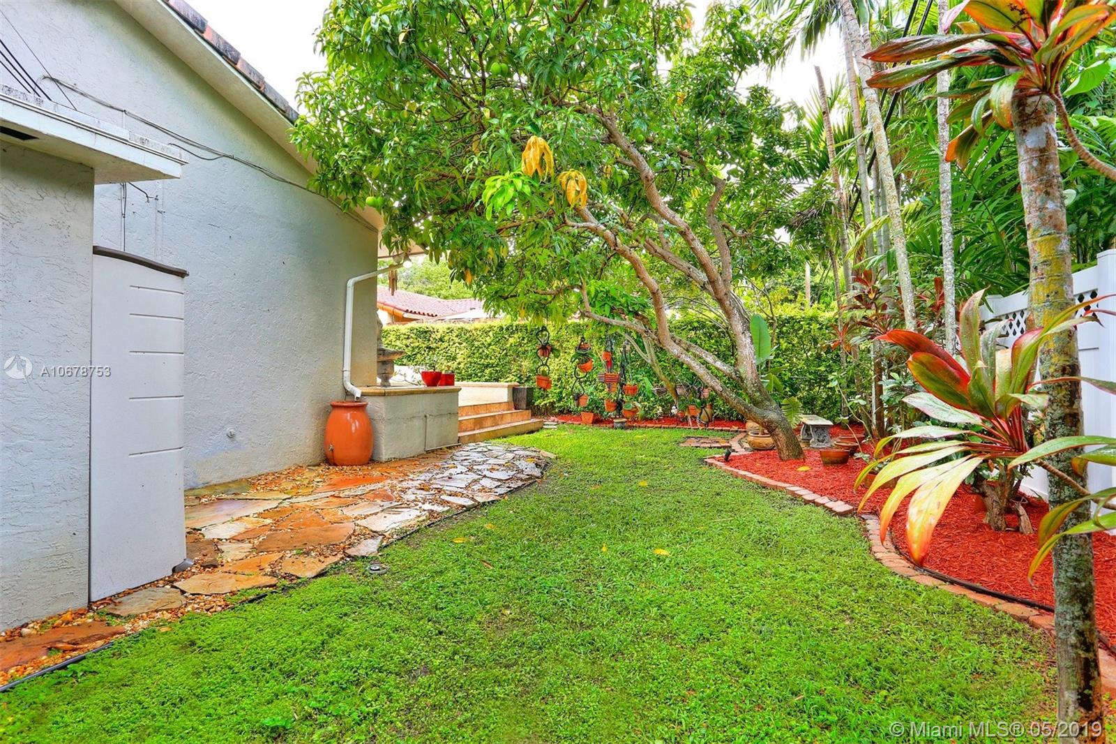 5939 Southwest 34th Street Miami, FL 33155 - Photo 28 of 30 Neatly-manicured back yard with fruitful mango tree, blooming flowers and additional storage room.