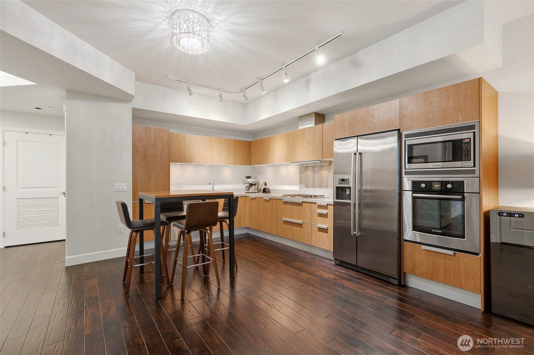 1920 4th Avenue, Unit 509 Seattle, WA 98101 - Photo 6 of 33 a kitchen with stainless steel appliances a dining table chairs stove and refrigerator