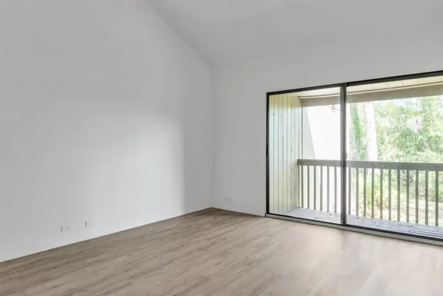 a view of a room with wooden floor and windows