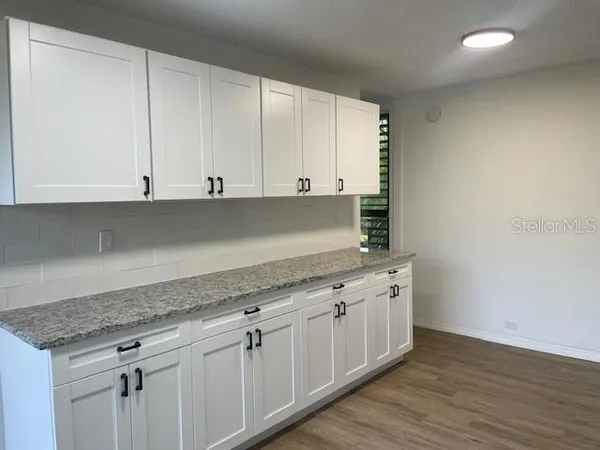 a view of a kitchen with white cabinets