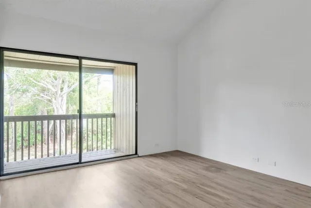 a view of a big room with wooden floor and windows