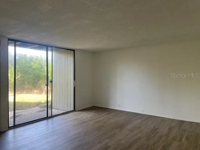 an empty room with wooden floor and glass door