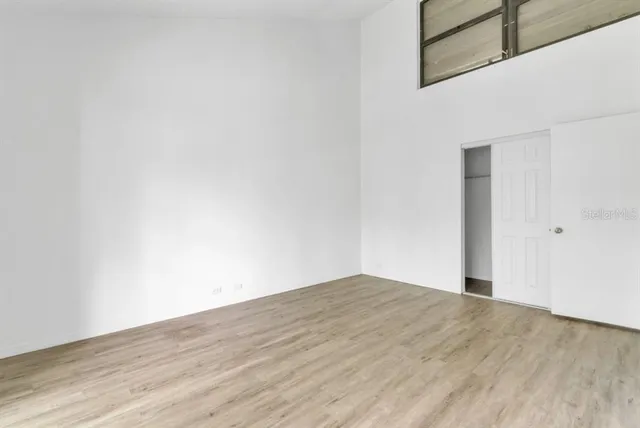a view of empty room with wooden floor