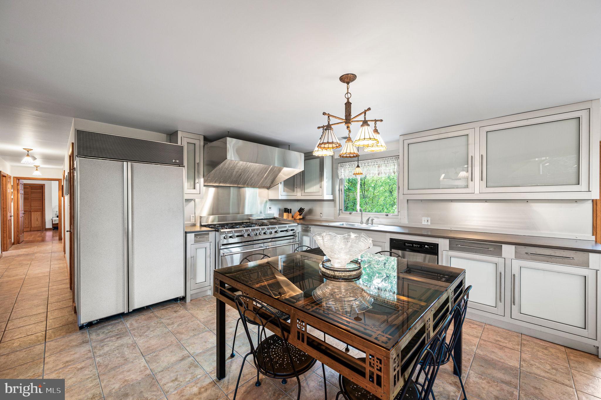 38 Lutz Road Boyertown, PA 19512 - Photo 14 of 49 a kitchen with stainless steel appliances a stove a sink dishwasher a dining table and chairs with wooden floor
