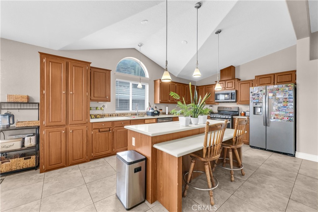 4901 Green River Road, Unit 102 Corona, CA 92878 - Photo 14 of 39 a kitchen with stainless steel appliances granite countertop a table chairs sink and cabinets