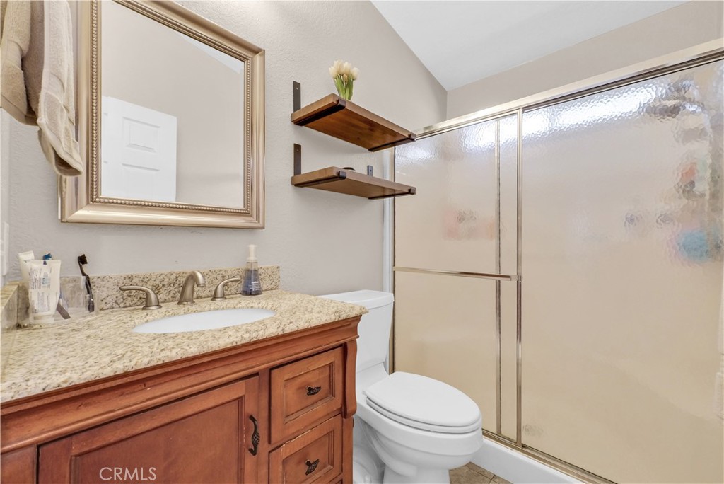 4901 Green River Road, Unit 102 Corona, CA 92878 - Photo 18 of 39 a bathroom with a granite countertop sink toilet and shower