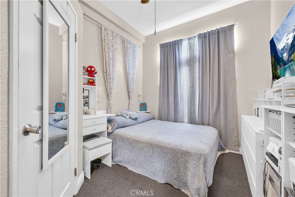 4901 Green River Road, Unit 102 Corona, CA 92878 - Photo 21 of 39 a bedroom with a bed and a flat tv screen