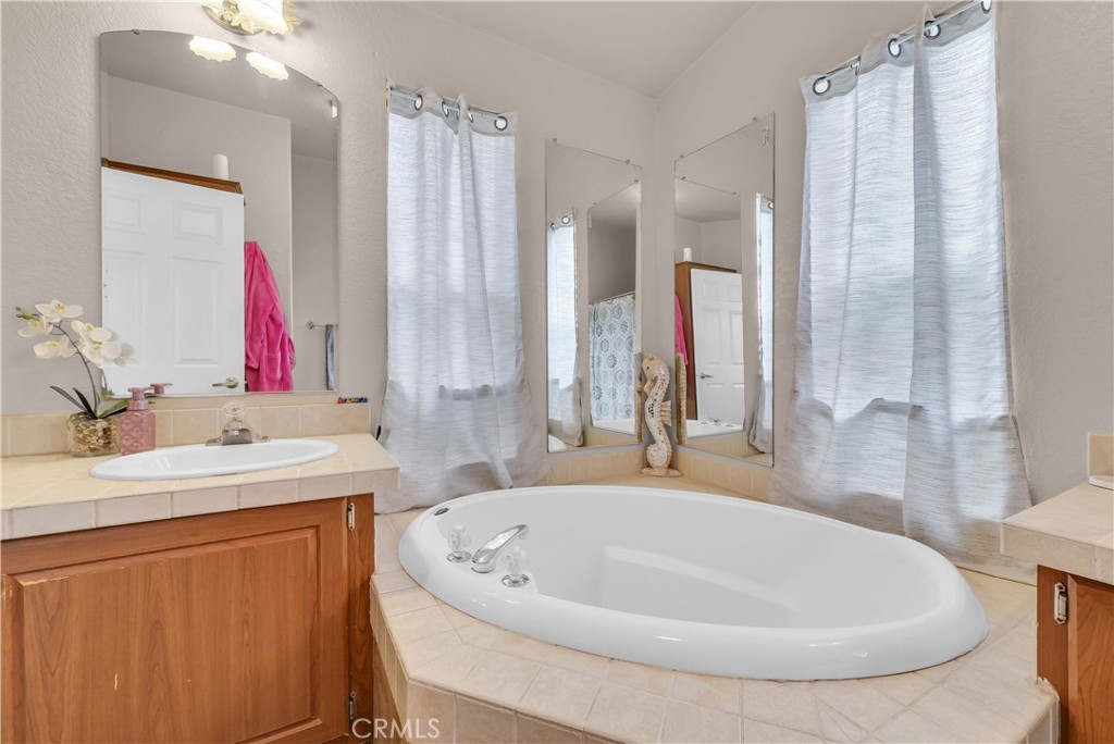 4901 Green River Road, Unit 102 Corona, CA 92878 - Photo 27 of 39 a bathroom with a tub sink and mirror