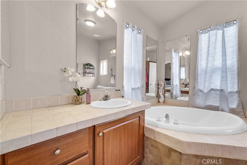 4901 Green River Road, Unit 102 Corona, CA 92878 - Photo 29 of 39 a bathroom with a tub sink and mirror