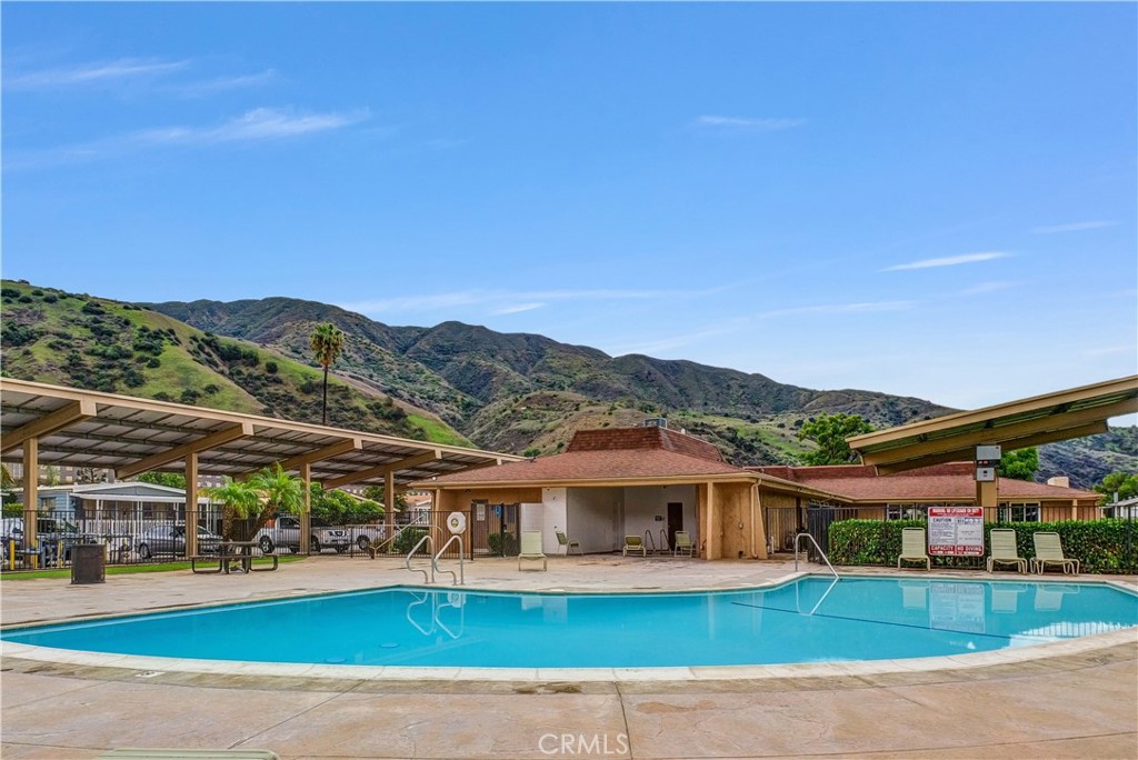 4901 Green River Road, Unit 102 Corona, CA 92878 - Photo 31 of 39 a view of a white house with a big yard and large trees