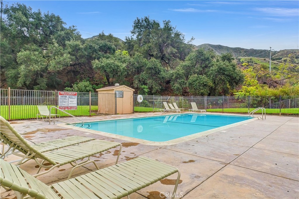 4901 Green River Road, Unit 102 Corona, CA 92878 - Photo 34 of 39 a view of a swimming pool with a patio and a yard