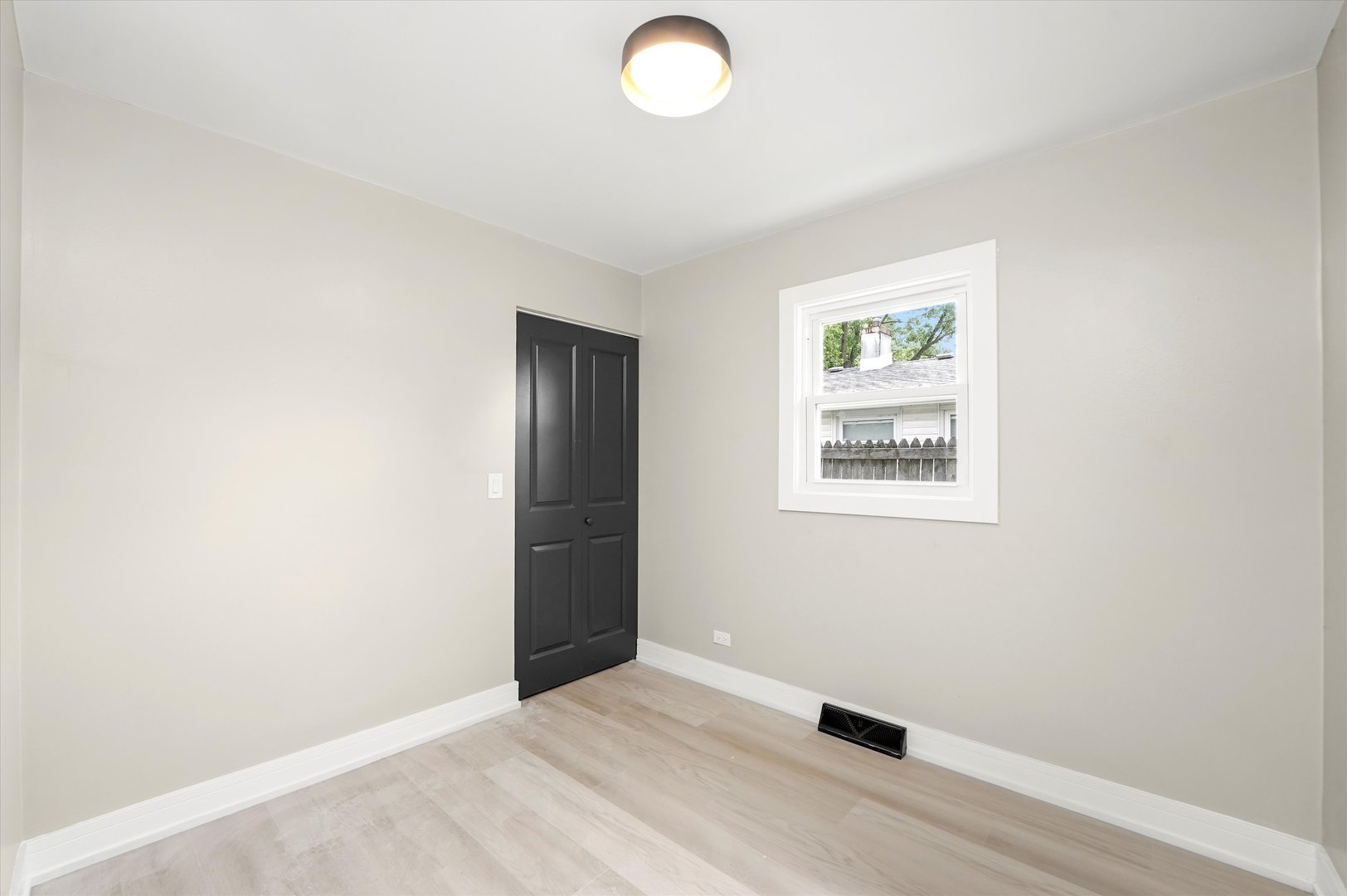 16218 Honore Avenue Markham, IL 60428 - Photo 14 of 25 an empty room with wooden floor and windows