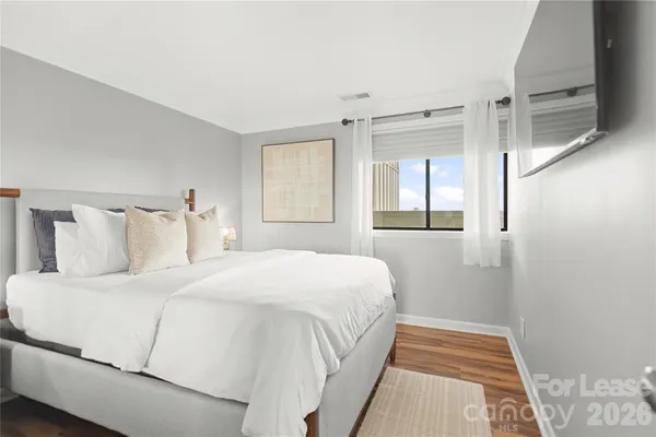 a bedroom with bed and wooden floor