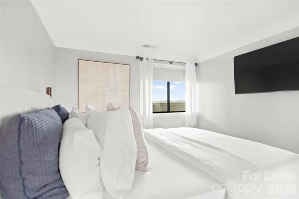 a bedroom with a bed and a flat screen tv