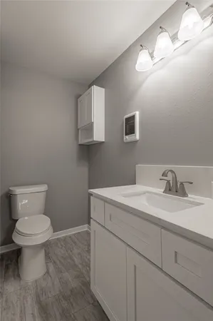 a bathroom with a granite countertop toilet sink and mirror