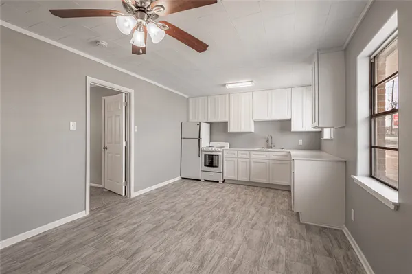 a kitchen with stainless steel appliances a white cabinets and wooden floor