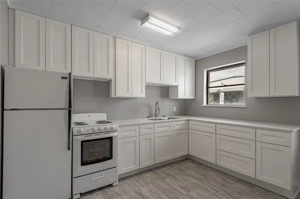a kitchen with white cabinets sink and white appliances