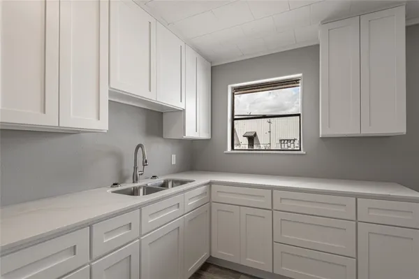 a kitchen with white cabinets and a sink