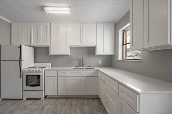 a kitchen with cabinets appliances a sink and a window