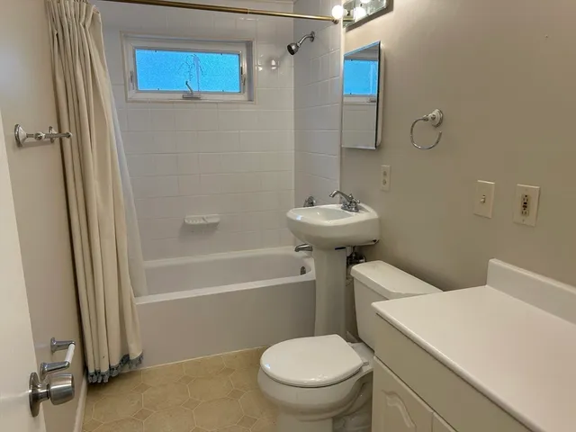 a white toilet sitting next to a bath tub