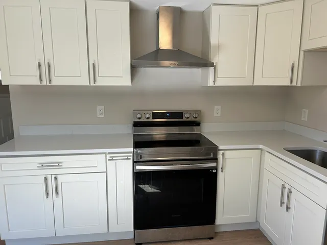 a kitchen with white cabinets and appliances