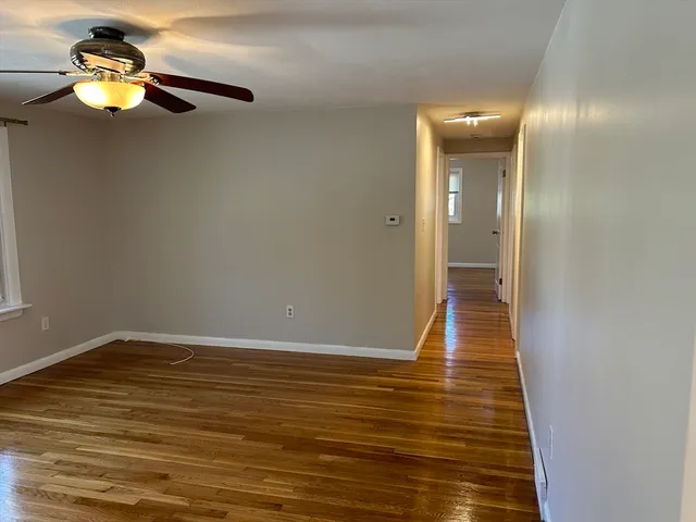 a view of empty room with wooden floor