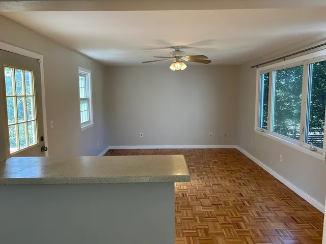 a view of empty room with wooden floor and window