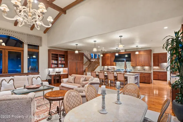 a living room with furniture a chandelier and a fireplace