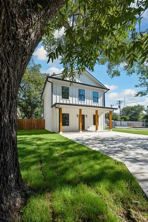 a front view of a house with a yard and trees